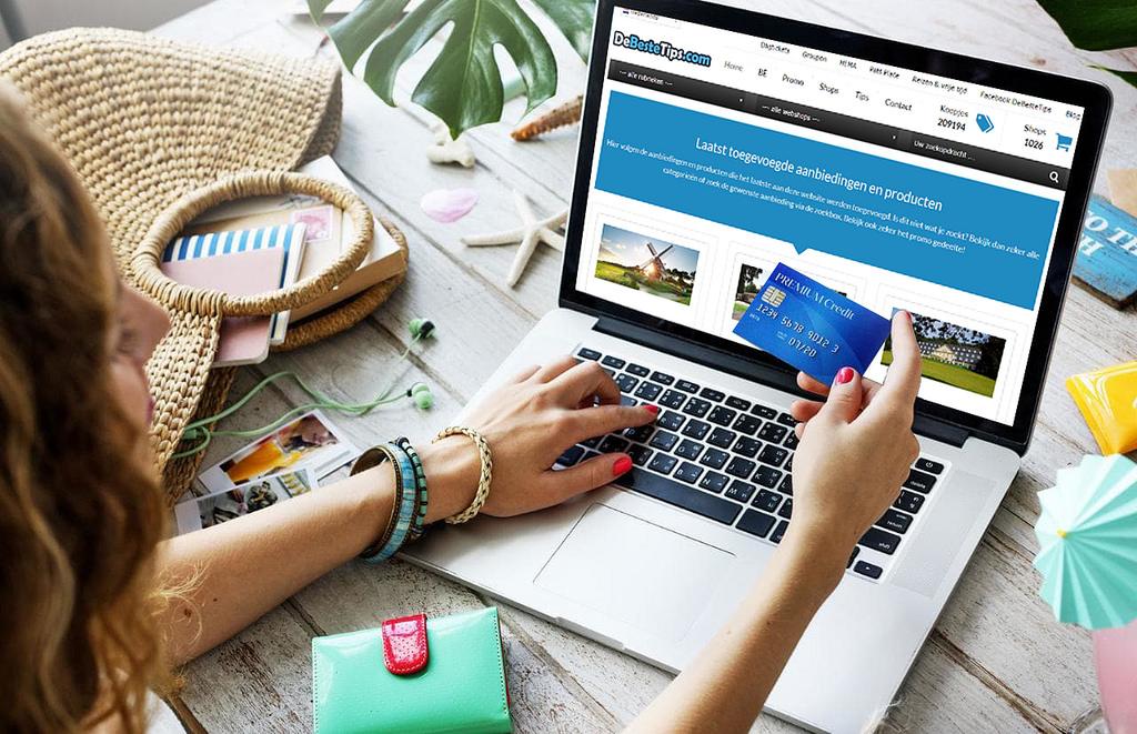 over-shoulder shot of a woman at her laptop, holding a credit card in her hand