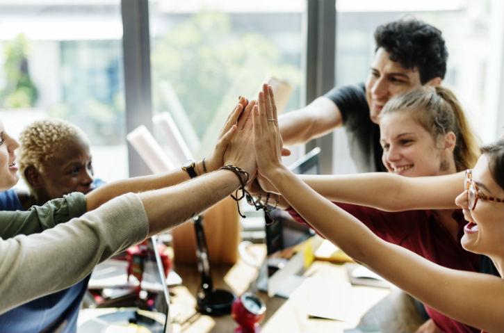 a group of several coworkers doing a group high-five