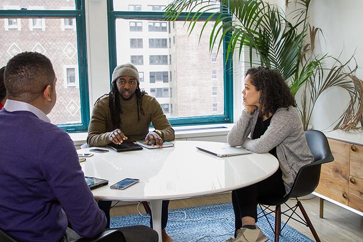 Four people seated at a round table.