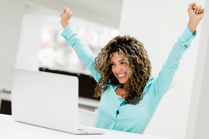 Happy woman at work looking at her laptop