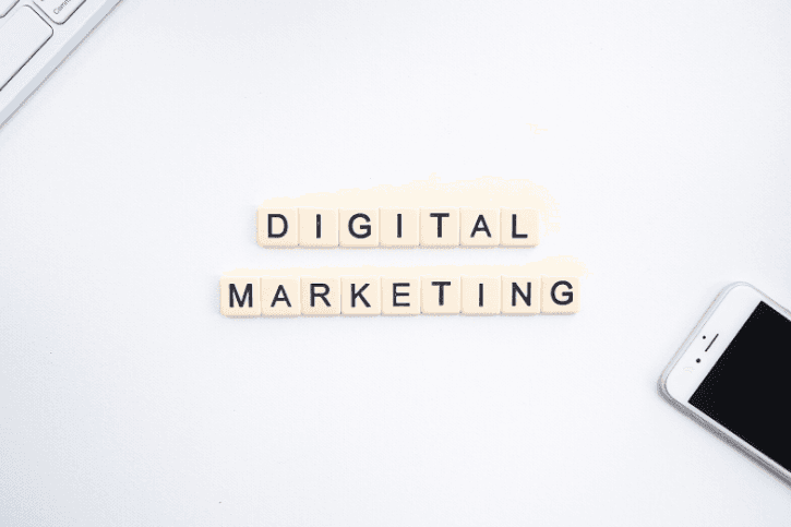 Letter titles on a white background spelling, "DIGITAL MARKETING." A keyboard and phone peek out of opposite corners.