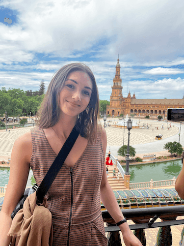 Kate smiles on balcony in Madrid with the Plaza de España behind her.