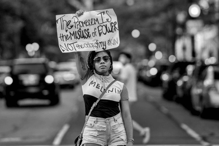 Joyce at a Black Lives Matter protest near the White House, holds a sign reading, "The Problem Is the Misuse of Power Not the Color of My Skin"